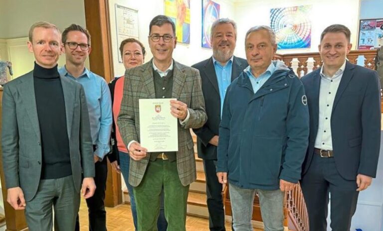 Bürgermeister Dr. Dietmar Thönnes – mit der Urkunde für seine zweite Amtszeit – und die Fachbereichsleitungen müssen die Gürtel enger schnallen. Denn das Defizit der Gemeinde ist erheblich. Darauf machen der Bürgermeister und Kämmerer Dominik Bomholt (r.) aufmerksam. Die Fachbereichsleitungen (v.l.): Stefan Kohaus, Christoph Bolle, Nicole Wortmann, Benedikt Gellenbeck und Peter Scheunemann.