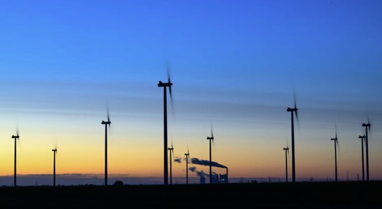 Windräder drehen sich vor der Kulisse des Braunkohlekraftwerks Schkopau, Sachsen-Anhalt.