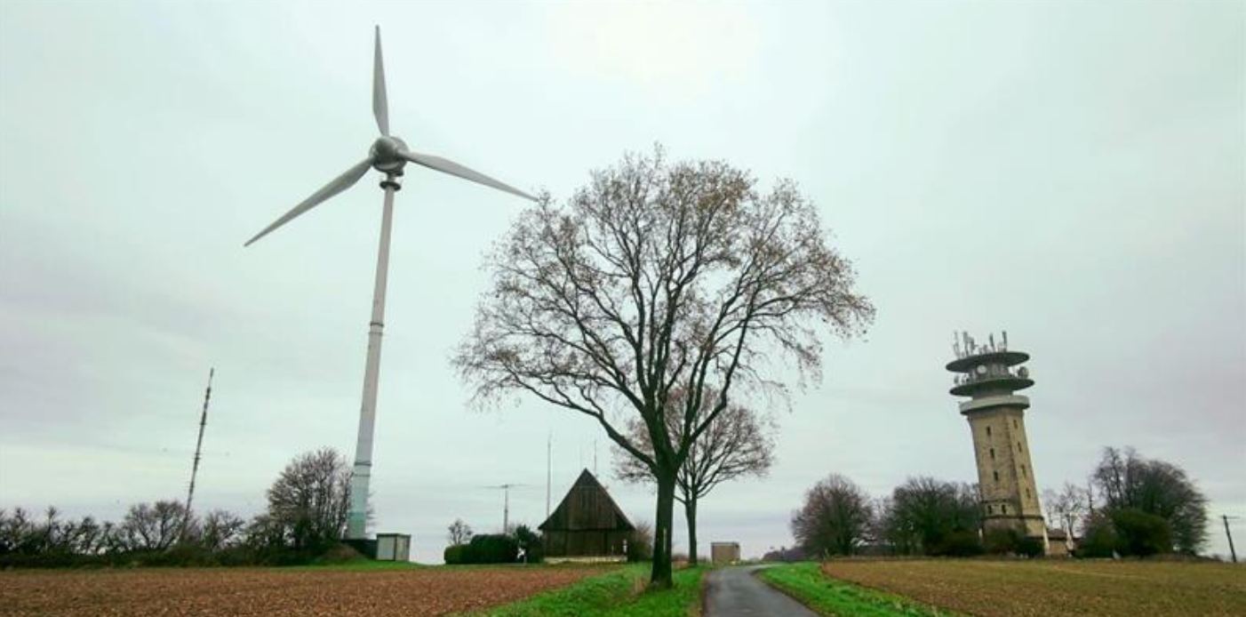 Das Weitwinkelobjektiv macht es möglich: Windrad und Longinusturm scheinen sich einander zuzuneigen. Im kommenden Jahr werden nach über 30 Jahren Betriebszeit die beiden Windkraftanlagen auf dem Westerberg abgebaut.